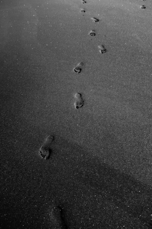 Grayscale Photo of Footprints on Sand