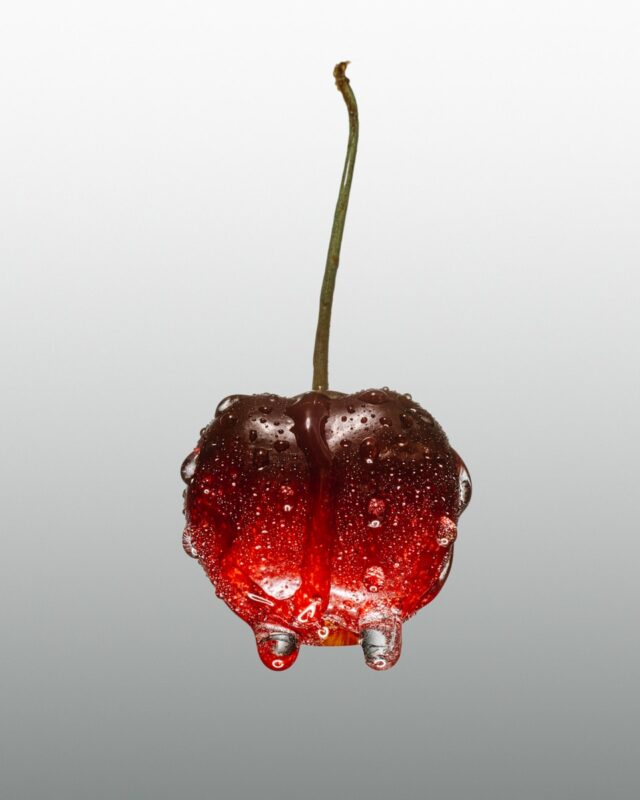 A cherry with water droplets hanging from it